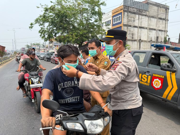 Kapolsek Pelawan Singkut dan Camat Singkut Bagikan Ratusan Masker di Tengah Kabut Asap